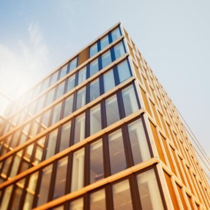 Edificio corporativo con fachada de vidrio expuesta a la radiación solar, donde la orientación de las ventanas influye en la elección de la película arquitectónica de control solar.
