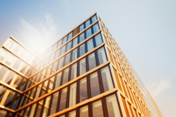 Edificio corporativo con fachada de vidrio expuesta a la radiación solar, donde la orientación de las ventanas influye en la elección de la película arquitectónica de control solar.