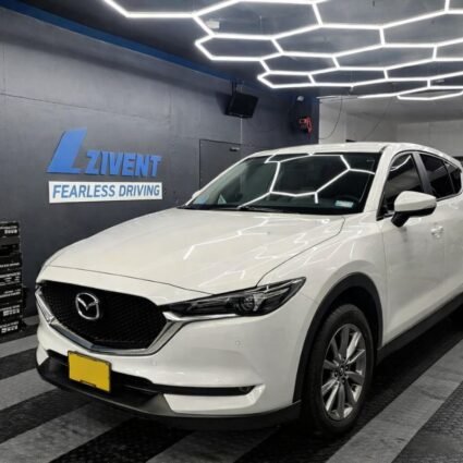 Vehículo Mazda blanco con polarizado nanocerámico Zivent instalado, ofreciendo protección solar, reducción de calor y acabado elegante en taller especializado.