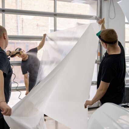 Técnico instalando película de protección de pintura (PPF) en un auto de forma profesional.