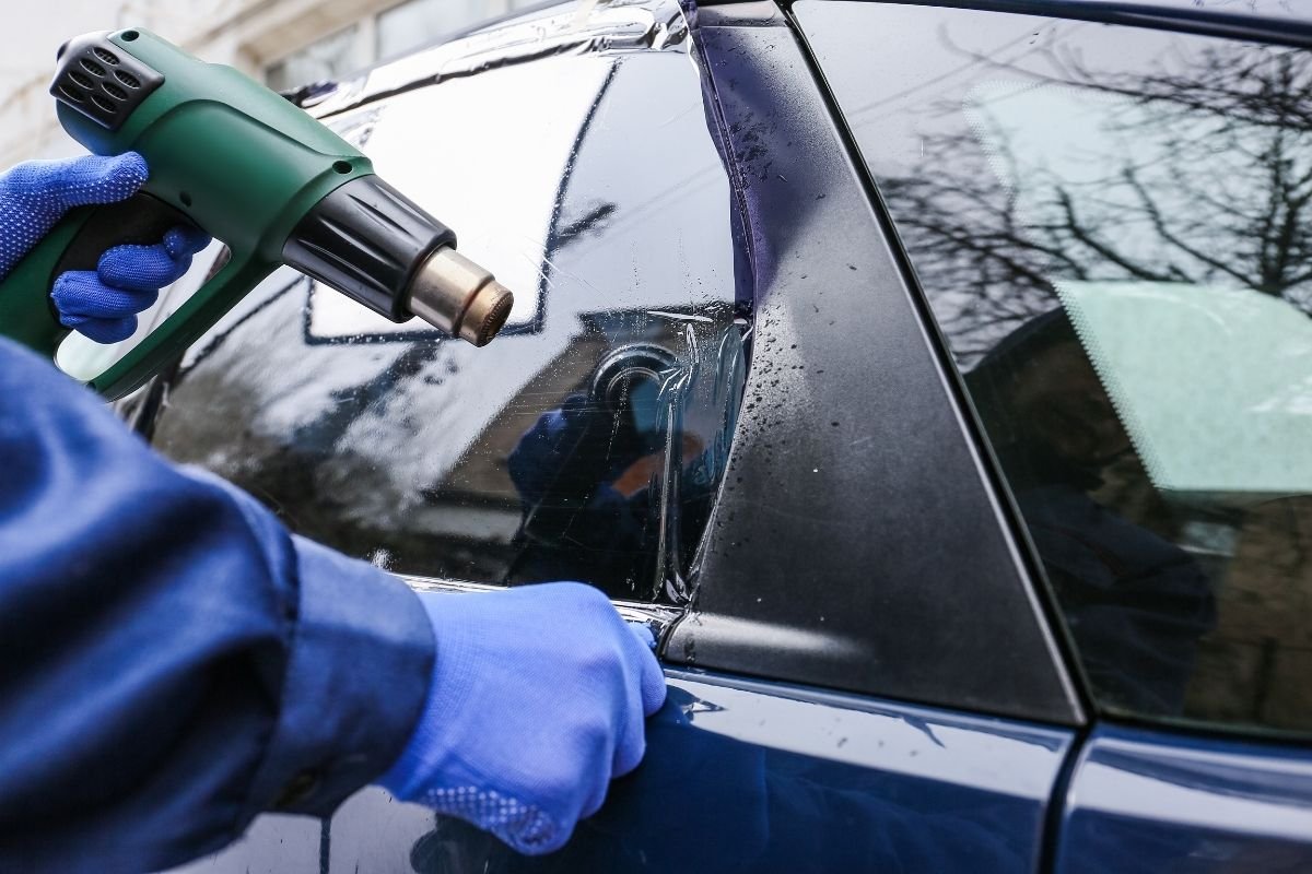 Instalador aplicando polarizado nanocarbon en el interior de un vehículo