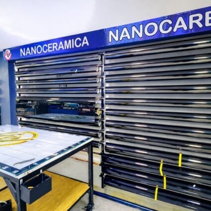 Rollos de láminas nanocerámicas y nanocarbono organizados en estantes dentro de un taller de instalación de polarizados.